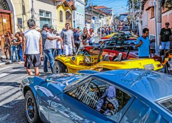 Carros pequenos expostos em diagonal e tomando toda a rua