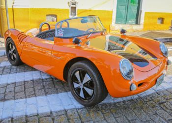 Carros pequenos expostos em diagonal e tomando toda a rua