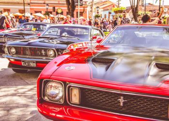 Carros pequenos expostos em diagonal e tomando toda a rua